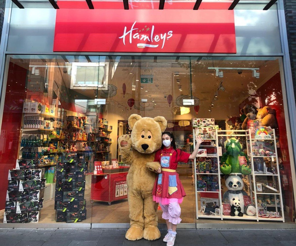 Hamley’s, Liverpool ONE A woman and a teddy bear, standing outside Hamleys toy store.